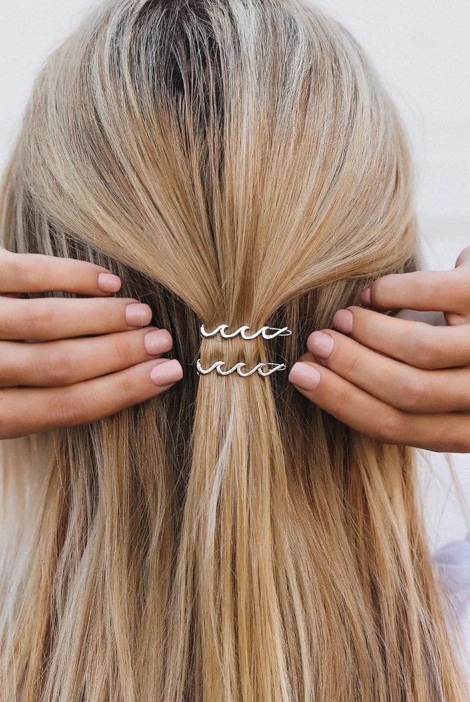 Back Of Girl's Head With Hands Putting In A Wave Silver Hair Clip | Podos Boutique