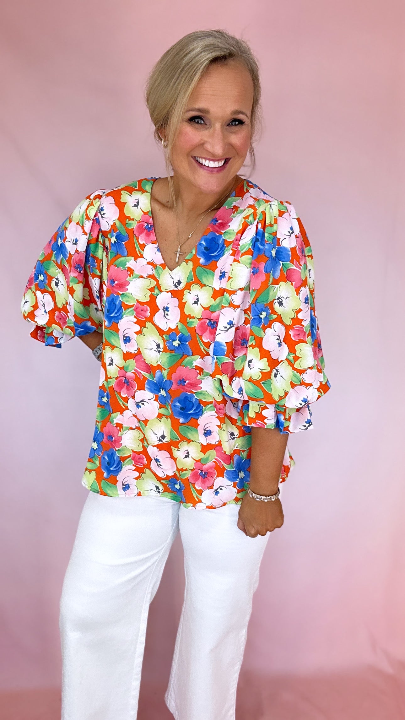 Girl Wearing a Orange, Blue, and Pink Floral Short Puff Sleeve V-Neck Blouse | Podos Boutique
