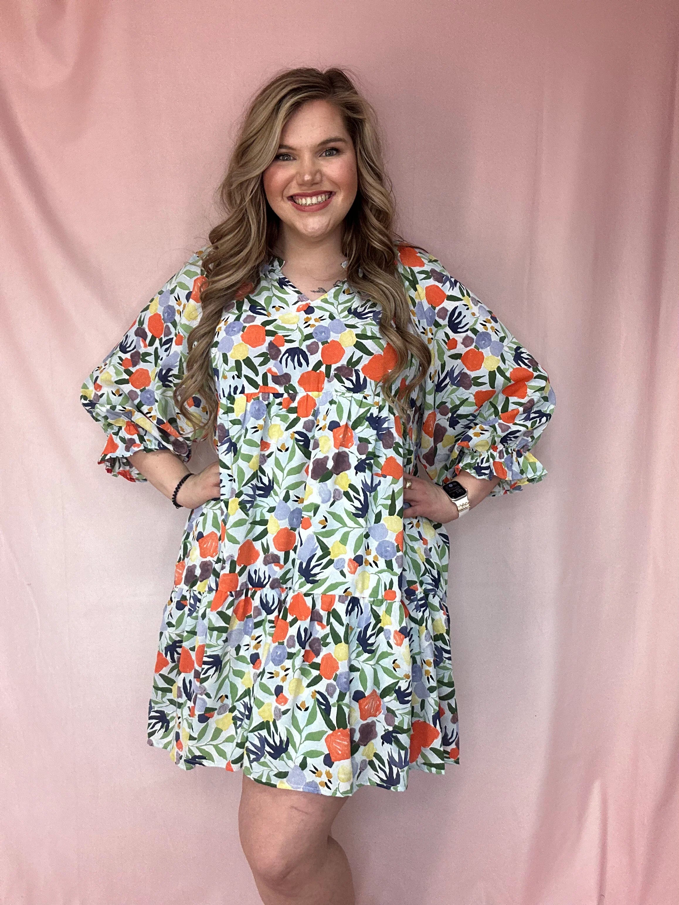 Girl Wearing A Long Puff Sleeve Orange, Blue, and Sage Floral Print Dress | Podos Boutique